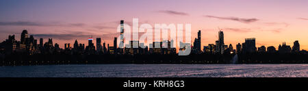 Sunset over Midtown and Hell's Kitchen, Manhattan, New York, USA. Viewed from the north across the Jaqueline Kennedy Onassis reservoir in Central Park Stock Photo