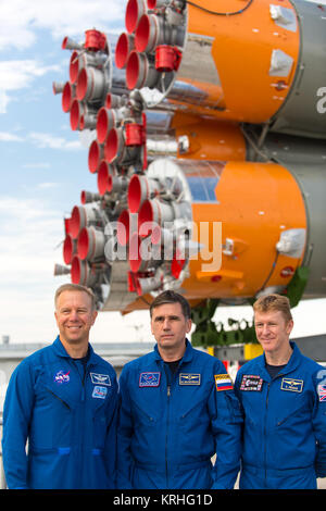 Expedition 44 backup crew members Timothy Kopra of NASA, left; Yuri Malenchenko of the Russian Federal Space Agency (Roscosmos), center; and Timothy Peake of the European Space Agency (ESA), right, pose for a photo as the Soyuz TMA-17M spacecraft is rolled to the launch pad by train on Monday, July 20, 2015 at the Baikonur Cosmodrome in Kazakhstan.  Launch of the Soyuz rocket is scheduled for July 23 and will carry Expedition 44 Soyuz Commander Oleg Kononenko of the Russian Federal Space Agency (Roscosmos), Flight Engineer Kjell Lindgren of NASA, and Flight Engineer Kimiya Yui of the Japan Aer Stock Photo