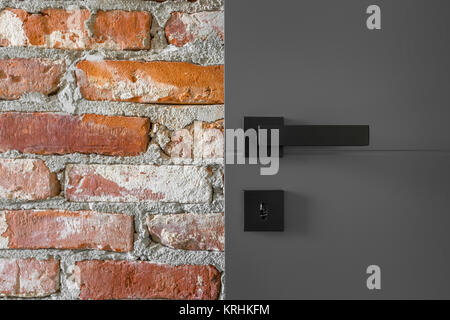 Simple door with black handle in exposed brick wall Stock Photo