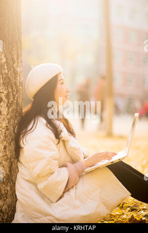 The work of the girl using laptops in the autumn garden Stock Photo