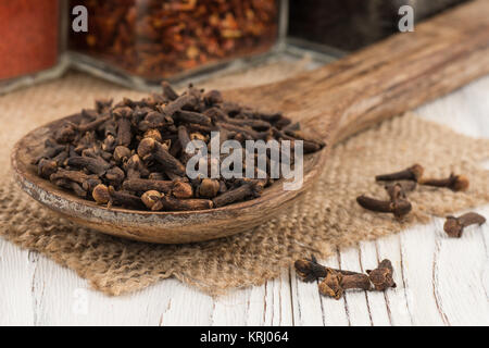 Spice cloves in a wooden spoon on old wooden table. Stock Photo