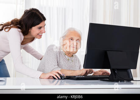 Two Smiling Women Using Laptop Stock Photo