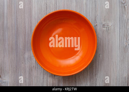 above view of orange bowl on gray brown table Stock Photo