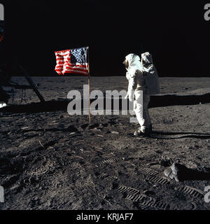 Astronaut Buzz Aldrin, lunar module pilot of the first lunar landing mission, poses for a photograph beside the deployed United States flag during an Apollo 11 Extravehicular Activity (EVA) on the lunar surface. The Lunar Module (LM) is on the left, and the footprints of the astronauts are clearly visible in the soil of the Moon. Astronaut Neil A. Armstrong, commander, took this picture with a 70mm Hasselblad lunar surface camera. While astronauts Armstrong and Aldrin descended in the LM, the 'Eagle', to explore the Sea of Tranquility region of the Moon, astronaut Michael Collins, command modu