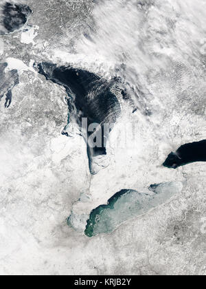 It is not unusual for the surface of Lake Erie to be covered by ice this time of year.  This true-color image was taken on February 8, 2004, by the Moderate Resolution Imaging Spectroradiometer (MODIS) aboard NASA's Terra satellite.  The scene shows ice covers most of Lake Erie, with the exception of a long narrow swath of surface water visible along its northern coastline.  The opening in the ice reveals light blue and turquoise patterns in the water, probably the result of sediments. Ice has also formed along most of the western coastline of Lake Huron, to the north.  (This  rapidfire.sci.gs Stock Photo