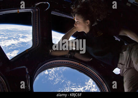 ISS024-E-014263 (11 Sept. 2010) --- NASA astronaut Tracy Caldwell Dyson, Expedition 24 flight engineer, looks through a window in the Cupola of the International Space Station. A blue and white part of Earth and the blackness of space are visible through the windows. Tracy Caldwell Dyson in Cupola ISS Stock Photo