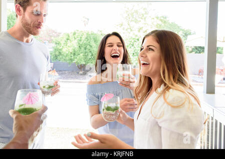 Smiling friends with cold drinks laughing outdoors Stock Photo