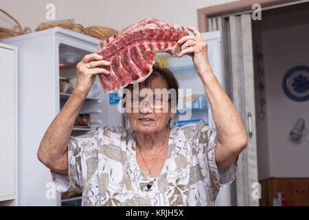 Senior woman with raw pork ribs Stock Photo