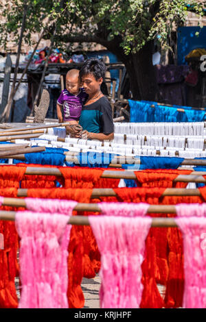 People and Colorful cotton yarn drying on a stick , in Myanmar , Asia. Near U Bein Bridge Stock Photo