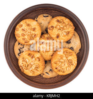 Cookies with peanuts and chocolate in a brown plate. Isolated on white background. Stock Photo