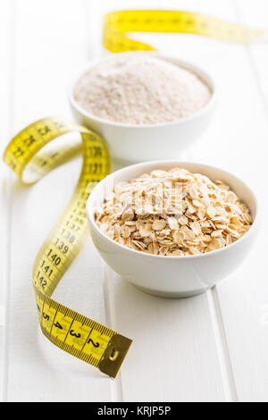 Diet concept. Oatmeal and measuring tape. Stock Photo