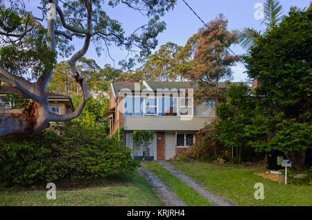 Beautiful Old Australian Suburban Houses. Street scene with brick and wooden building exterior, driveway and garden with trees at Brookvale, Sydney, N Stock Photo