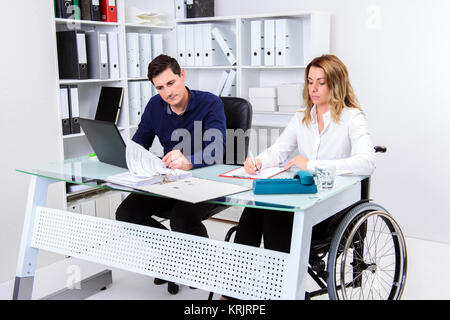 colleague disabled business woman in wheelchair and her Stock Photo