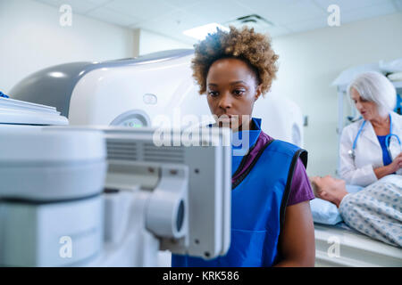 Technician preparing scanner for doctor comforting patient Stock Photo