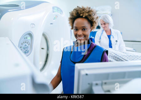 Smiling technician preparing scanner for doctor comforting patient Stock Photo