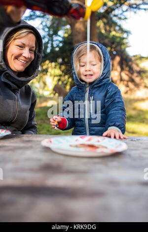 Caucasian mother pouring syrup on pancake for daughter Stock Photo