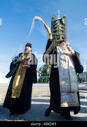 An Orthodox Priest blesses members of the media at the Baikonur Cosmodrome launch pad on Monday, Dec. 14, 2015 in Kazakhstan. Launch of the Soyuz is scheduled for Dec. 15 and will send Expedition 46 Soyuz Commander Yuri Malenchenko of the Russian Federal Space Agency (Roscosmos), Flight Engineer Tim Kopra of NASA, and Flight Engineer Tim Peake of ESA (European Space Agency) to the International Space Station for a six-month stay. Photo Credit: (NASA/Joel Kowsky) Expedition 46 Soyuz Blessing (NHQ201512140035) Stock Photo