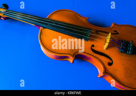 The old violin lies on a blue background Stock Photo