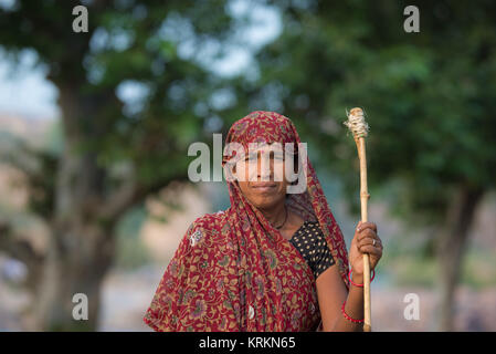 Orchha, India - November 16, 2017: portrait of indian woman with stick, outdoors in the countryside at Ocrhha, India. Stock Photo