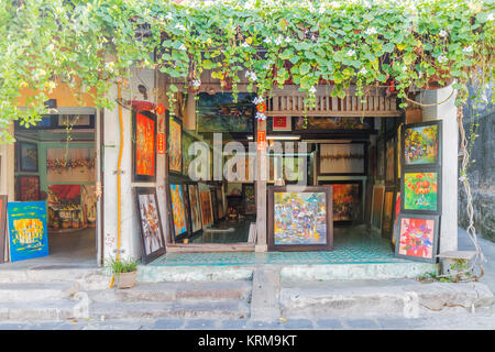 Shop selling paintings on Hoi An ancient town, Vietnam. lovely old, historic Hoi An home with yellow walls and plants climbing up the walls Stock Photo