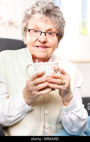 the old lady drinking a brew of herbs. grandma's first aid kit,infusion of herbs. Stock Photo