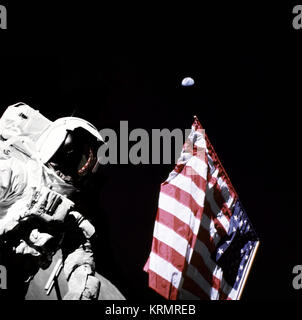 Geologist-Astronaut Harrison Schmitt, Apollo 17 Lunar Module pilot, is photographed next to the American Flag during extravehicular activity (EVA) of NASA's final lunar landing mission in the Apollo series. The photo was taken at the Taurus-Littrow landing site. The highest part of the flag appears to point toward our planet earth in the distant background.  NASA Identifier: GPN-2000-001137 Schmitt with Flag and Earth Above (8252450191) Stock Photo