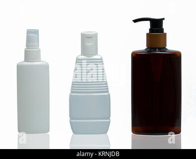 Three white and brown plastic cosmetic bottles with different type of cap : pump, spray and cap isolated on the white background with blank label and  Stock Photo