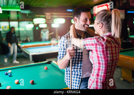 Young couple playing together pool in bar Stock Photo