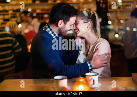 Happy couple kissing at bar and having date Stock Photo