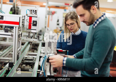 Two young handsome engineers working on electronics components Stock Photo
