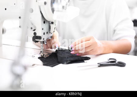 sewing machine. the woman sews on the machine. Stock Photo