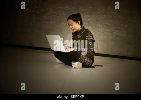 Asian girls sitting on the floor using laptops Stock Photo