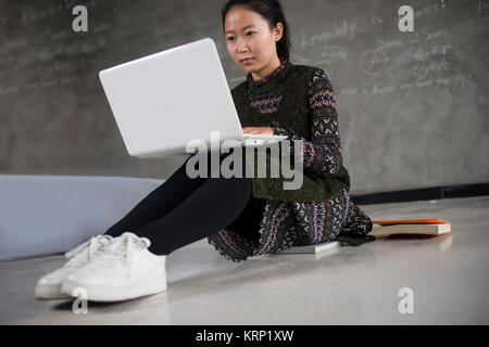 Asia Female college students use laptops.The blackboard to write full formula of the background. Stock Photo