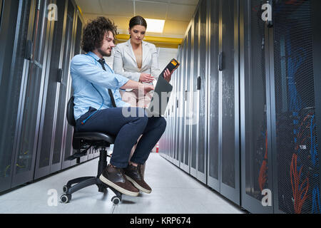 two young technicians working at a data center on server maintenance Stock Photo