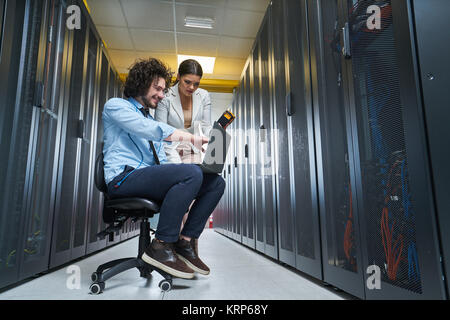 two young technicians working at a data center on server maintenance Stock Photo