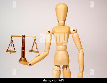 Holzpuppe mit Messingwaage, Symbolbild Gerechtigkeit - jointed doll with scale Stock Photo