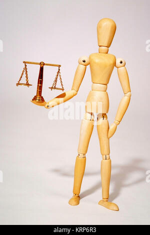 Holzpuppe mit Messingwaage, Symbolbild Gerechtigkeit - jointed doll with scale Stock Photo