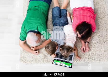 Multi Generation Family Using Laptop At Home Stock Photo