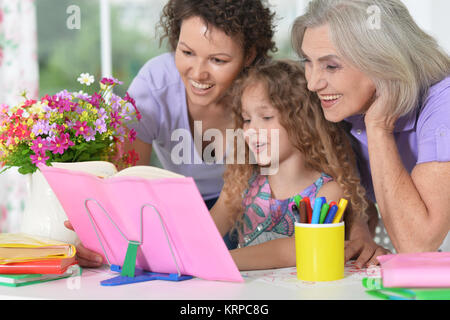 three generations of women from one family doing homework Stock Photo