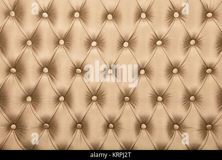 Beige capitone textile background, retro Chesterfield style checkered soft tufted fabric furniture diamond pattern decoration with buttons, close up Stock Photo