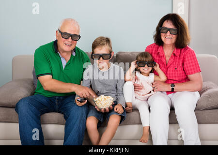 Grandparent And Grandchildren Watching 3D Movie Stock Photo