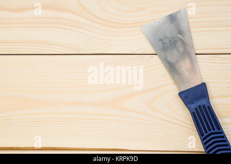 Repairing and construction concept. A close up of a plastering trowel on a light uncolored wooden background. Top view. Space for your text or pruduct Stock Photo