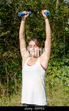 Fitness woman doing exercises with dumbbells Stock Photo