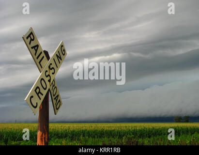 A line of strong thunderstorms approaches a railroad crossing in Illinois farm country. Stock Photo