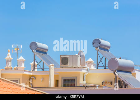 Solar collectors and boilers with airco on roof of house Stock Photo