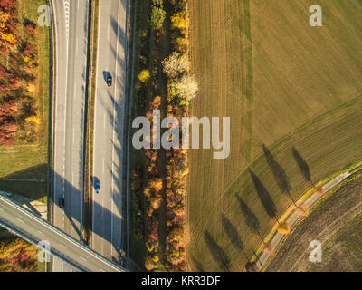 Aerial view of a highway amid fields with cars on it Stock Photo