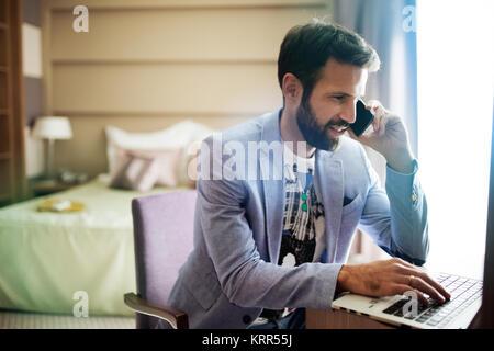 Portrait of successful young handsome man using laptop Stock Photo