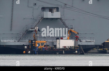 A Multicat support vessel at the stern of HMS Queen Elizabeth, after it was announced there was a leak from one of her propeller shafts. Stock Photo