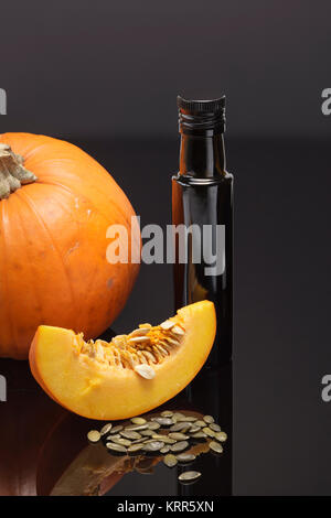 large orange pumpkin with pumpkinseed oil and pumpkinseeds Stock Photo
