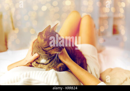 young woman with cat lying in bed at home Stock Photo